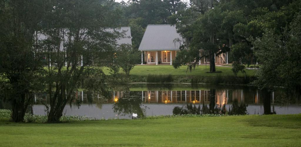 uma casa com um lago em frente em Greenwood Plantation B&B Inn em Saint Francisville