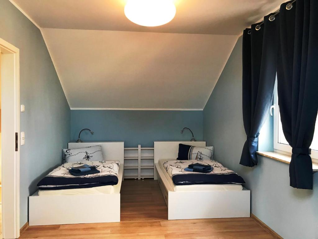 Duas camas num quarto com paredes azuis em Haus Kranichweide em Bodstedt