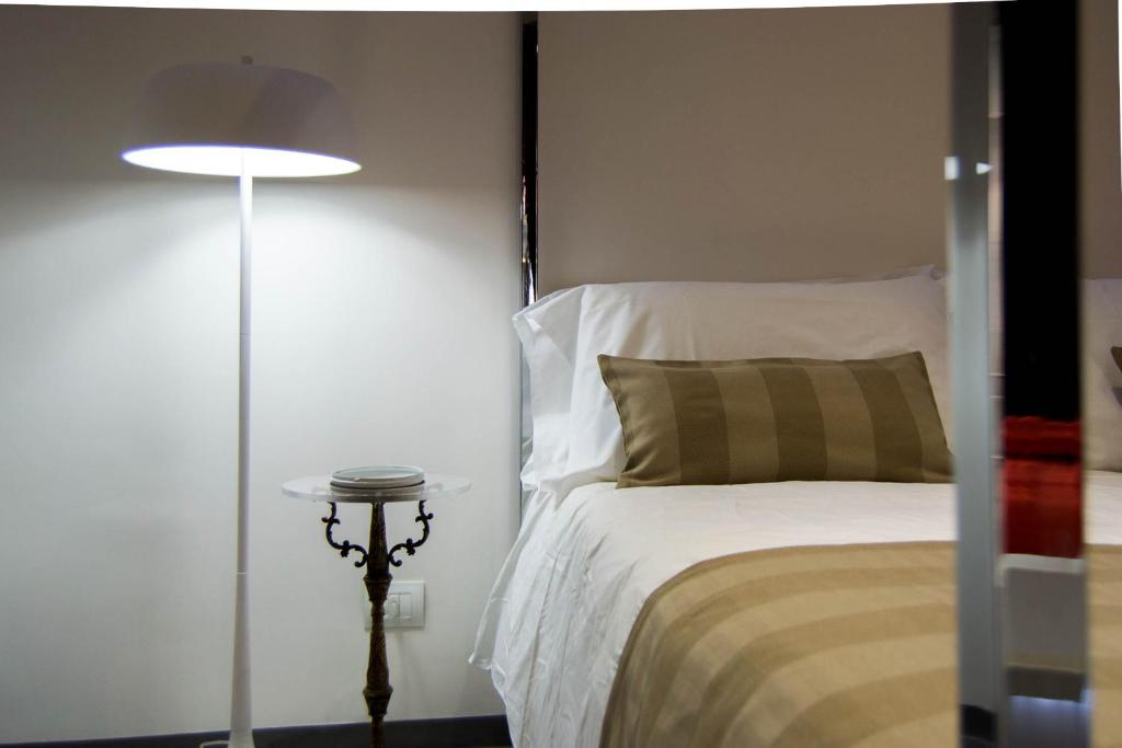 a bedroom with a bed and a floor lamp at Hotel Santa Brigida in Naples