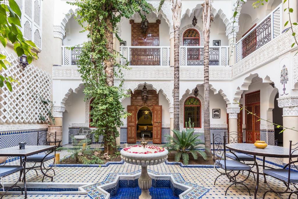 a courtyard with tables and chairs in a building at Riad Tahyra in Marrakesh
