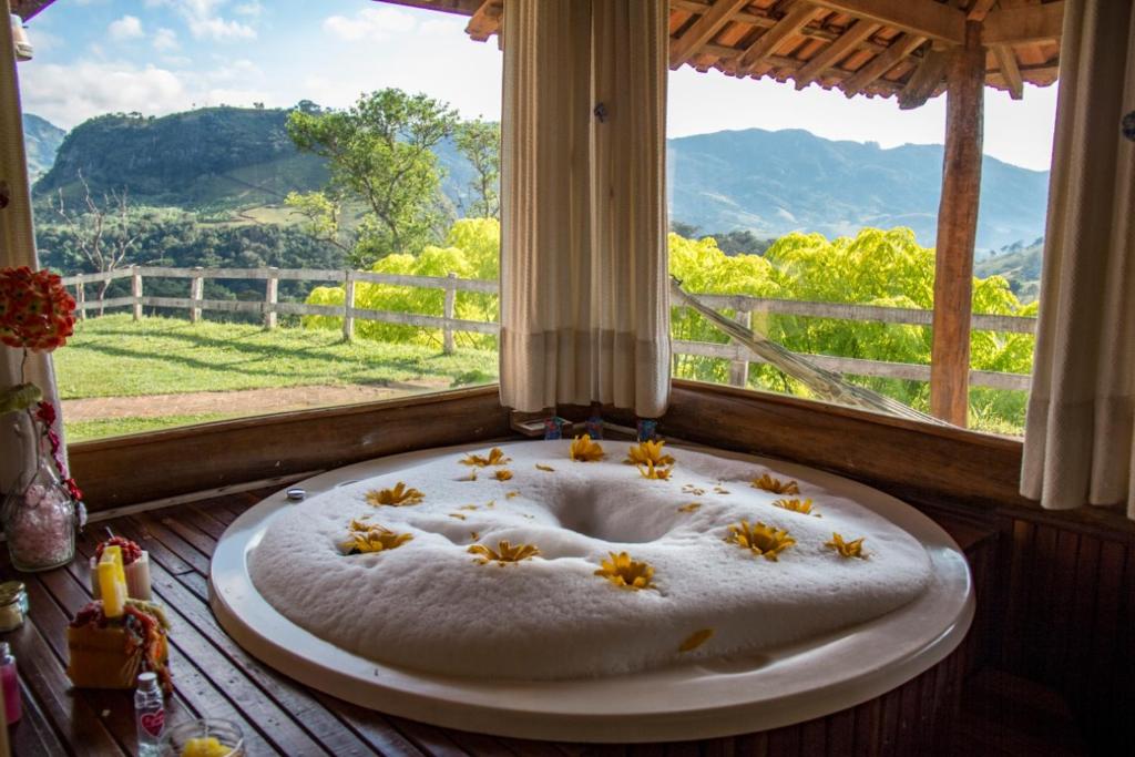 a bath tub with stars in a window with a view at Pousada Dona Manoela in Gonçalves