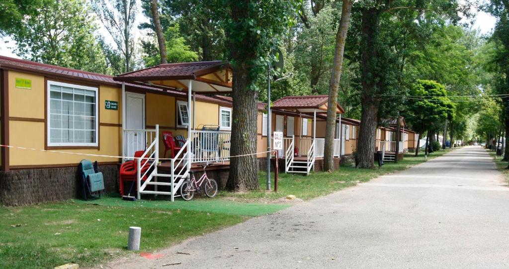 eine Reihe von Häusern auf einer Straße mit Bäumen in der Unterkunft Camping Fuentes Blancas in Burgos
