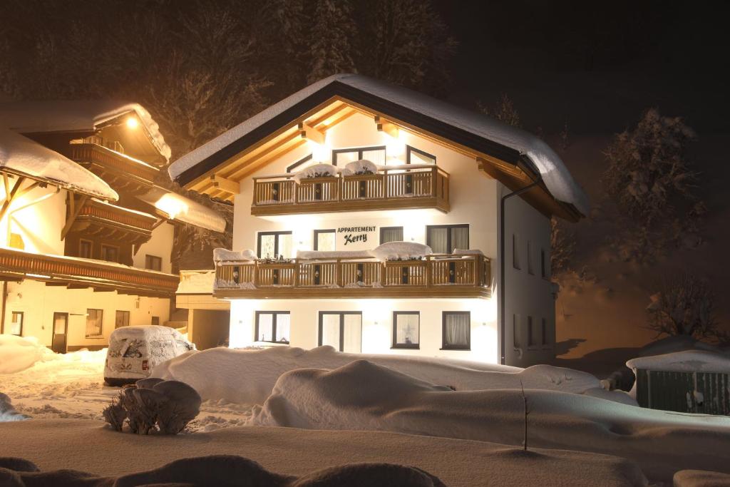 un bâtiment avec un balcon dans la neige la nuit dans l'établissement Appartement Kerry, à Schladming
