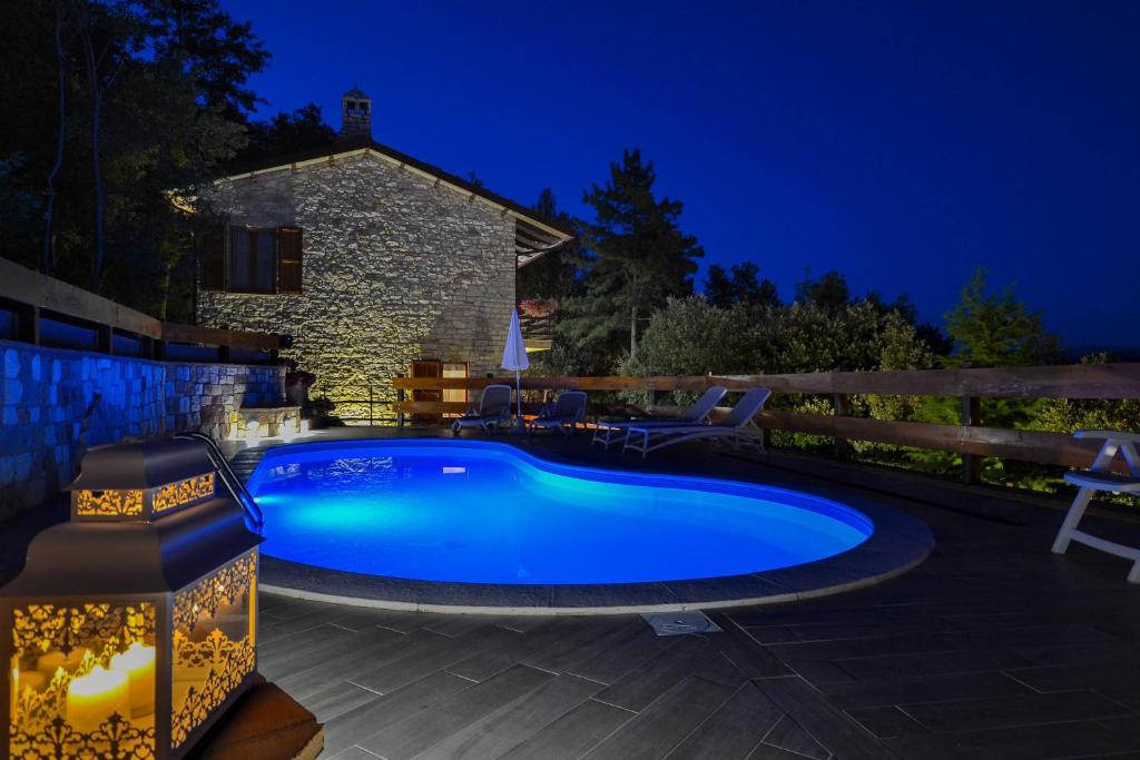 una piscina en un patio trasero por la noche en VillaSubasioRelax, en Spello
