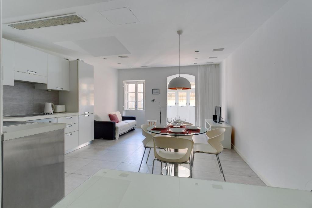 a kitchen and dining room with a table and chairs at Valletta Studio Apartment in Valletta