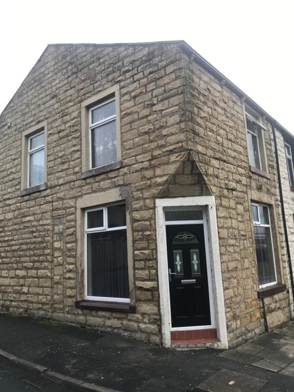 a brick building with a black door and windows at Entire B&B in Burnley