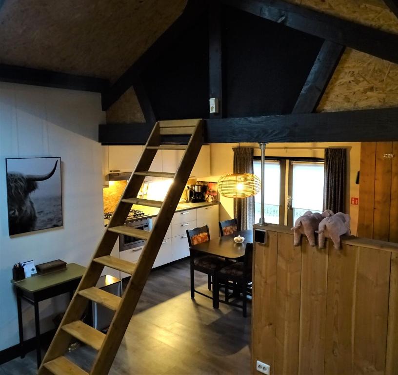 a room with a staircase and a dining room and a kitchen at De Oude Stoffeerderij in Dussen