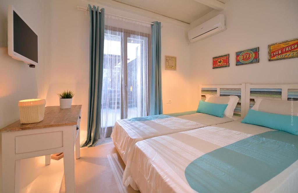 sypialnia z łóżkiem, biurkiem i oknem w obiekcie Villa Kimothoe by Thalassa Residence Mykonos w mieście Elia