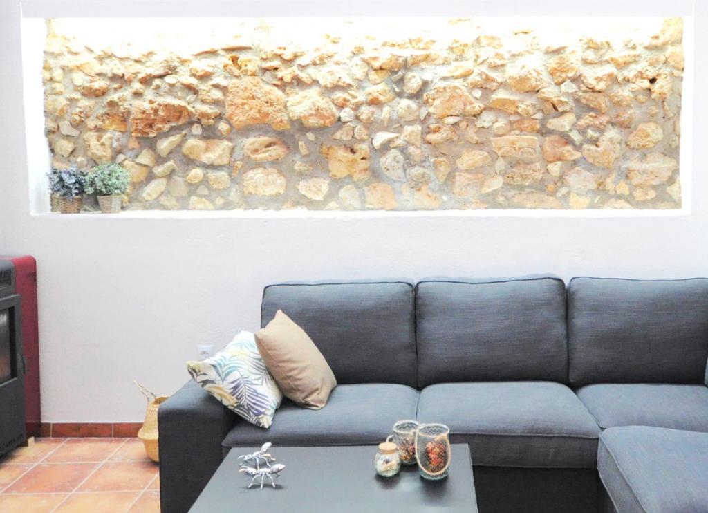 CASA JOTA في ليرما: غرفة معيشة مع أريكة ولوحة على الحائط