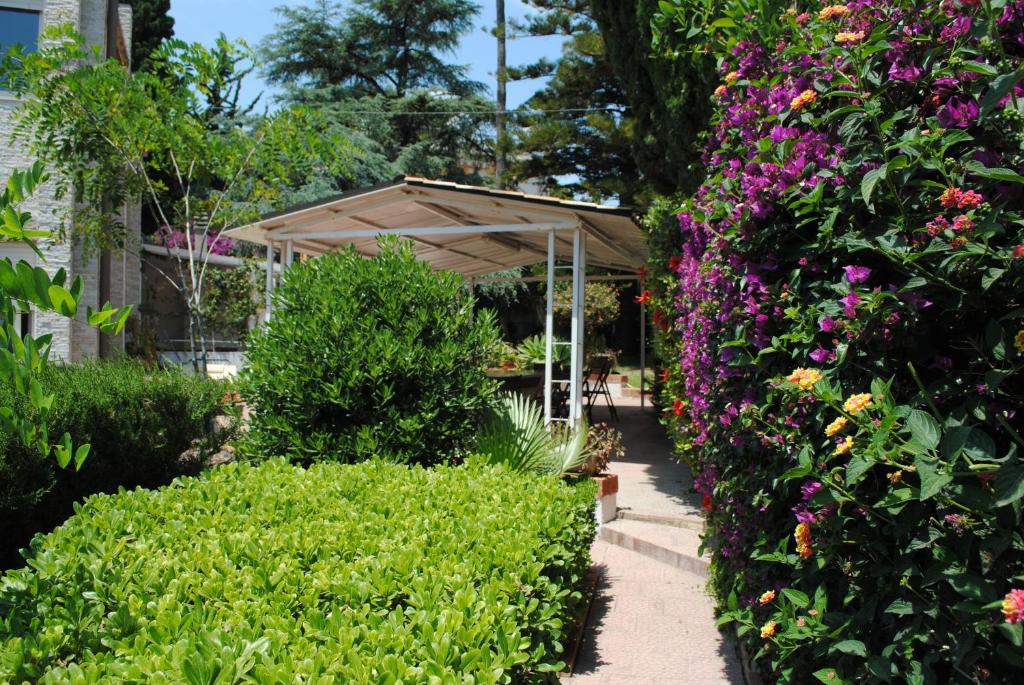 a garden with a pavilion and colorful flowers at Summer Beach Rooms in Fontane Bianche