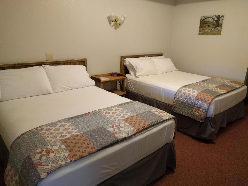 a hotel room with two beds in a room at The BarnwooD Inn in Humansville