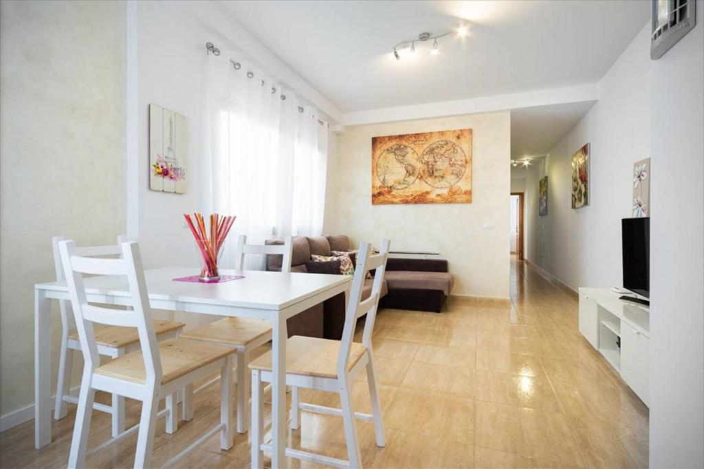 een eetkamer en een woonkamer met een witte tafel en stoelen bij Canary House Gold in Vecindario