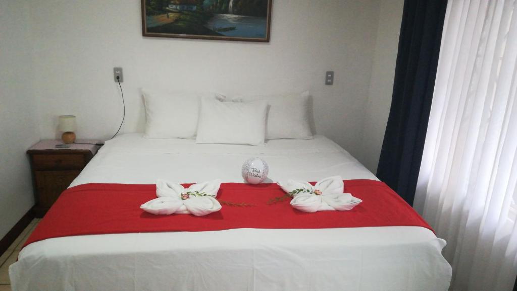 Un dormitorio con una cama blanca con arcos. en Casa Mariana, en Alajuela
