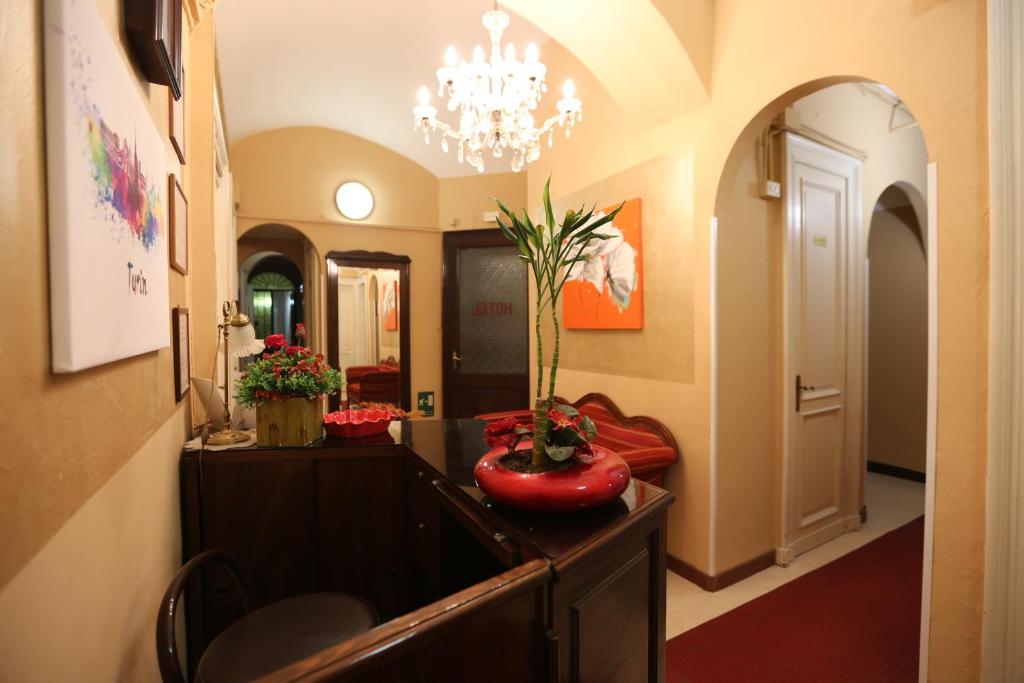 都靈的住宿－Hotel Vinzaglio，走廊上设有一张桌子上带花瓶的房间