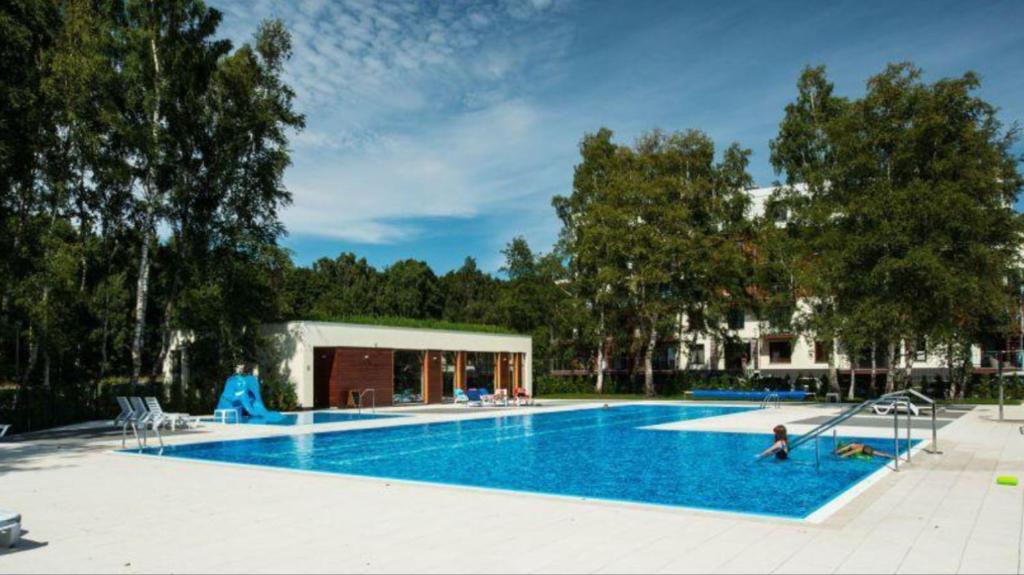 a large swimming pool with people sitting around it at KOLOBRZEG apartamenty GREG POLANKI in Kołobrzeg