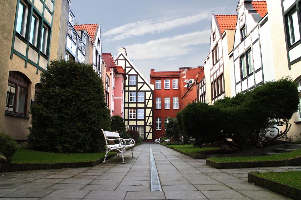 a bench sitting on a sidewalk in front of buildings at Bielski Guesthouse in Gdańsk