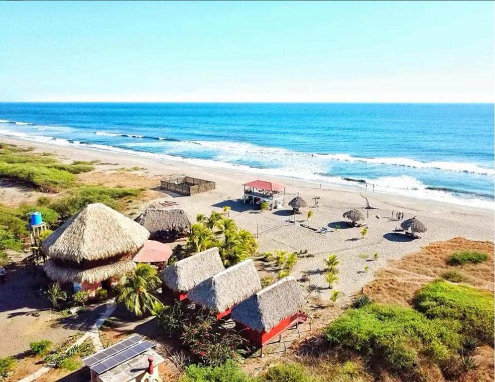 an aerial view of a beach with houses and the ocean at Surfing Turtle Lodge in Poneloya