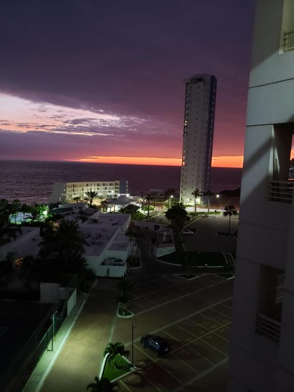 a view of a city at sunset from a building at Ocean Club Playas in Playas