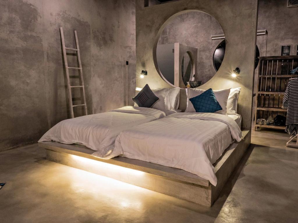 una camera da letto con un grande letto e un grande specchio di Gunung An Retreat ad Ubud