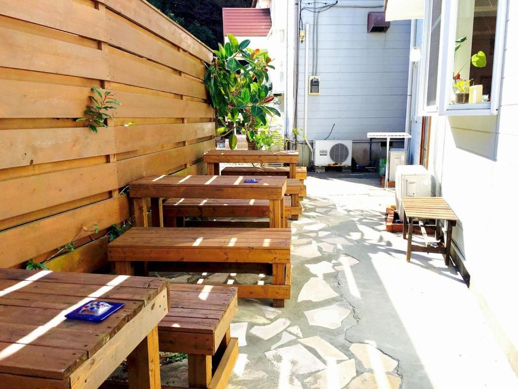 a row of wooden benches on a patio at Beach Side Inn Shirahama in Shimoda