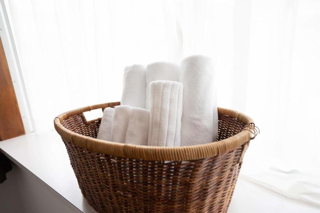 a basket filled with white towels on a counter at Beach Side Inn Shirahama in Shimoda