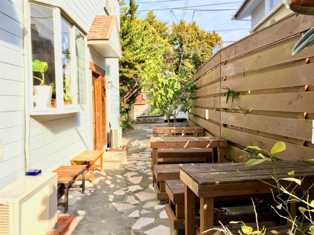a patio with wooden tables and benches next to a building at Beach Side Inn Shirahama in Shimoda