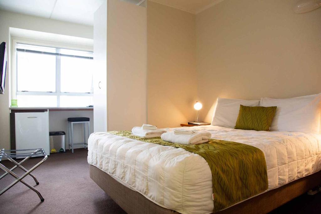 a bedroom with a bed with towels on it at City Lodge Accommodation in Auckland