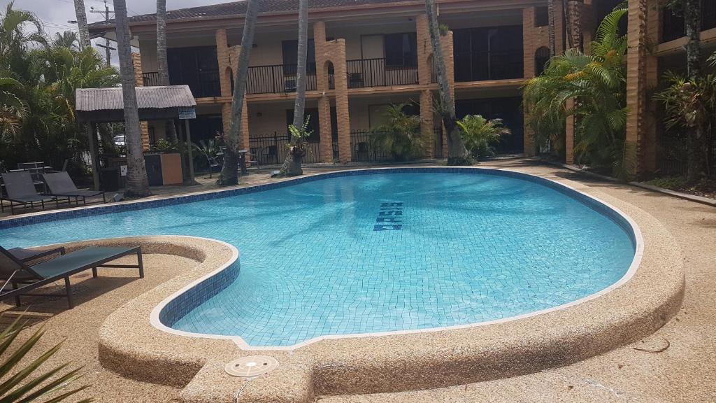 a large swimming pool in front of a building at Oasis Inn Apartments in Cairns