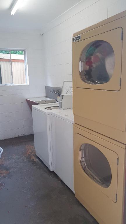 a laundry room with a washer and dryer at Oasis Inn Apartments in Cairns