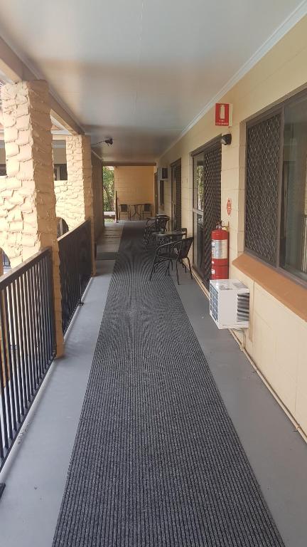 an empty porch of a building with black flooring at Oasis Inn Apartments in Cairns