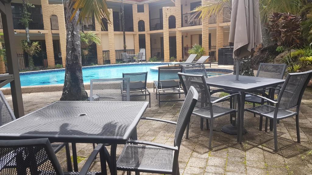 a group of tables and chairs next to a pool at Oasis Inn Apartments in Cairns