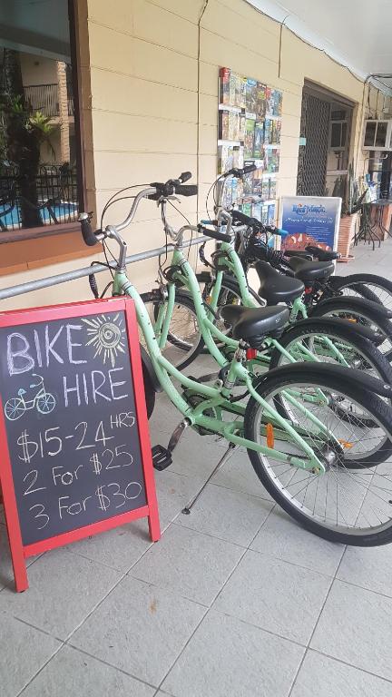 a group of bikes parked next to a sign at Oasis Inn Apartments in Cairns