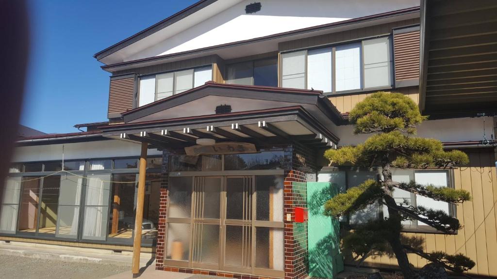 una casa con un toldo en la parte delantera en Minshuku Iwaki en Fujikawaguchiko