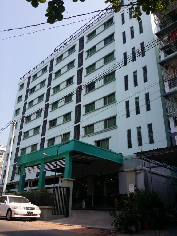 un edificio blanco con un coche aparcado delante de él en Silver Green Hotel, en Yangón