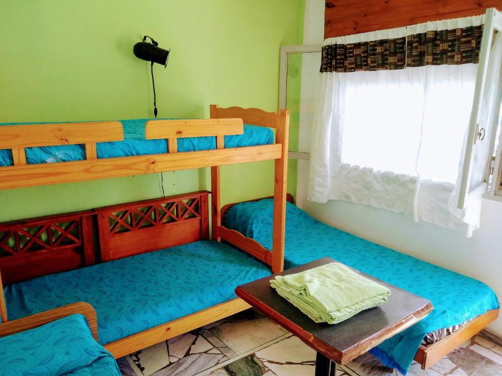 a room with two bunk beds and a table at Hostel Megaró in Santa Teresita