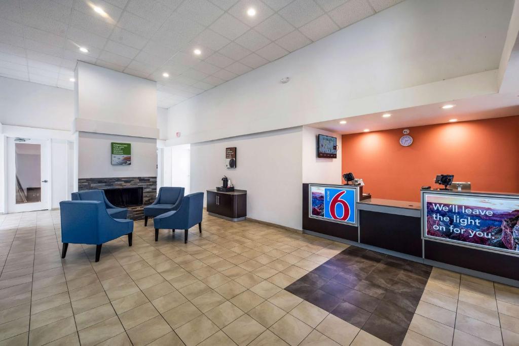 a waiting area in a hospital with chairs and a tv at Motel 6-Irving, TX - Irving DFW Airport East in Irving