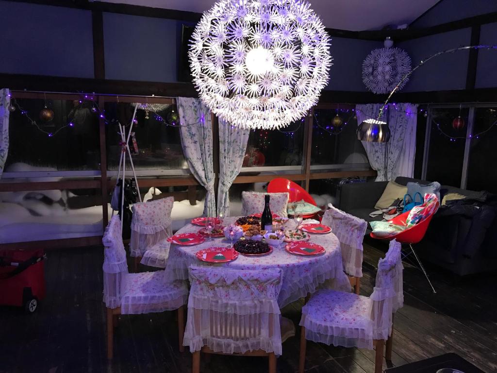 einem lila Tisch mit Stühlen und einem Kronleuchter in der Unterkunft Naeba Ski Resort - Cottage away from usual life in Yuzawa