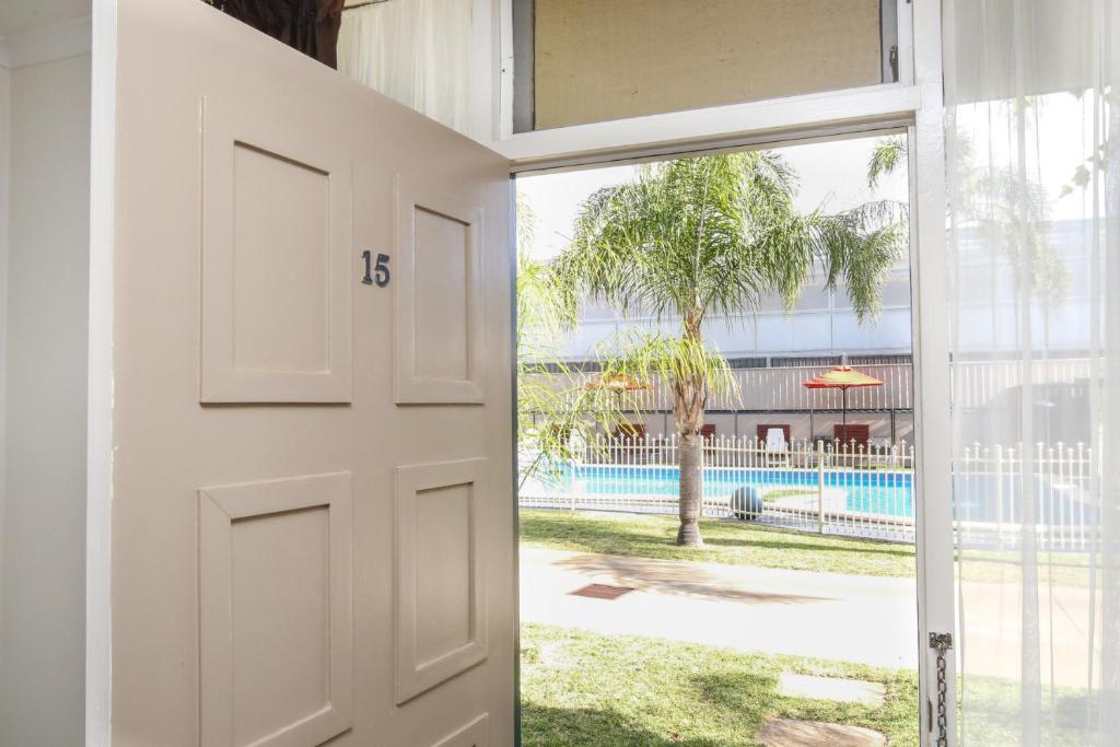 a door is open to a patio with a view of the water at Sandors Motor Inn in Mildura