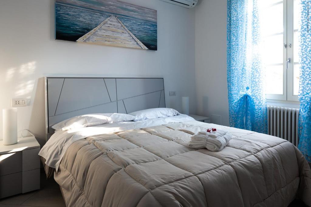 sypialnia z dużym białym łóżkiem z niebieskimi zasłonami w obiekcie La Meridiana w mieście Piacenza