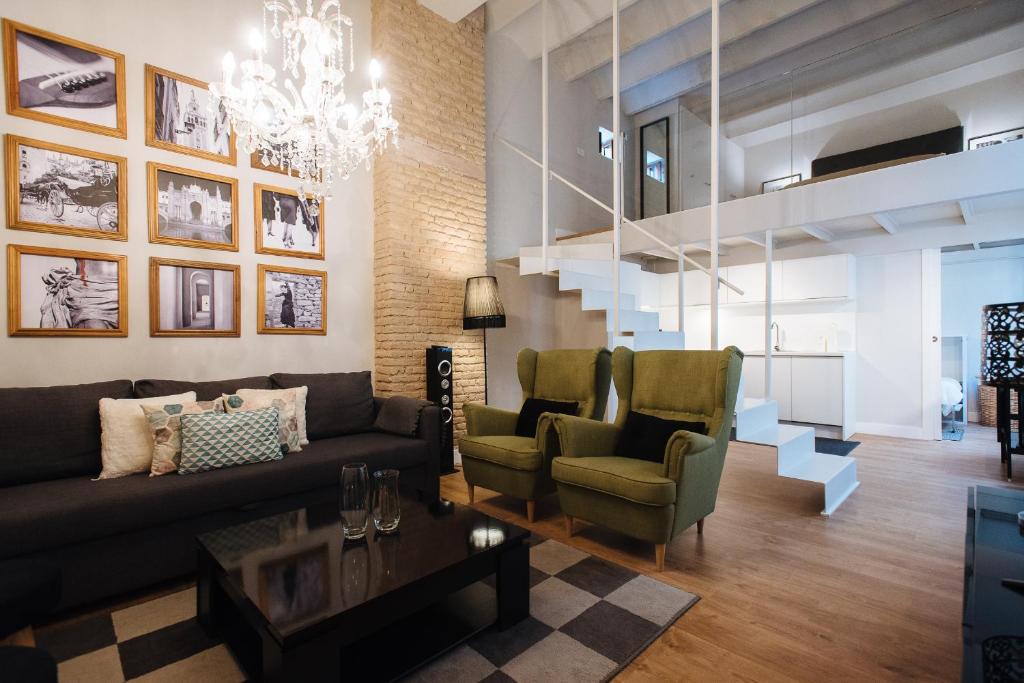 a living room with a couch and chairs and a staircase at Hommyhome San Isidoro in Seville