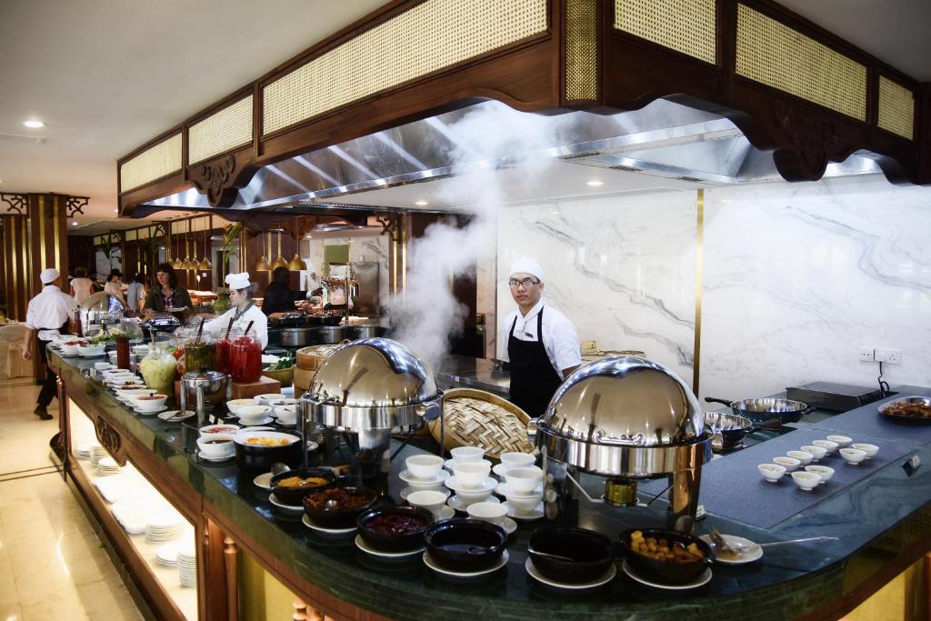 An open buffet kitchen with chefs preparing food behind a long counter.