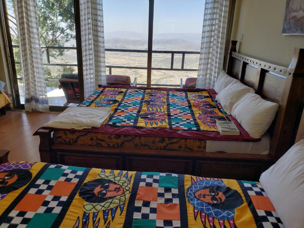 two beds in a room with a view of the ocean at Top Twelve Hotel - Lalibela in Lalibela