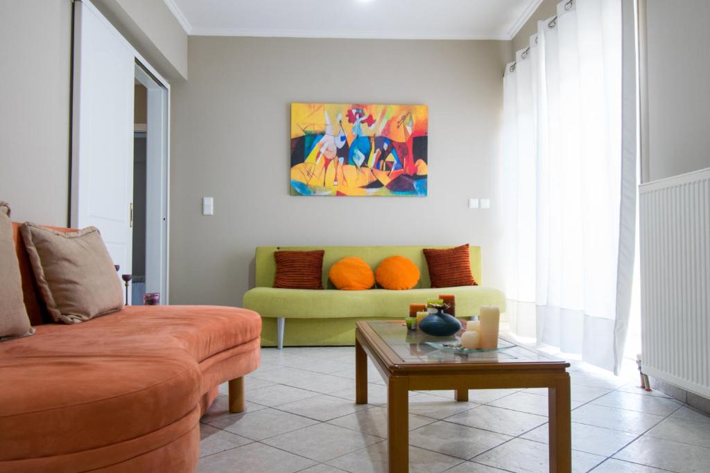 uma sala de estar com um sofá e uma mesa em BETTY'S AIR+PORT SEA APARTMENT em Artemida