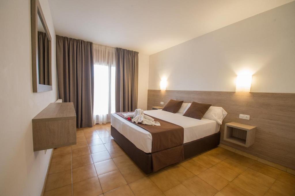 a hotel room with a bed and a window at Hotel Hipica Park in Platja d'Aro