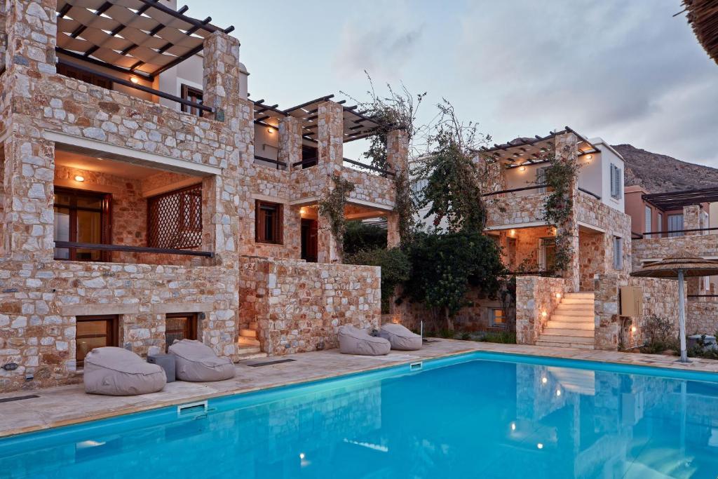 ein Haus mit einem Pool vor einem Gebäude in der Unterkunft Plagia Villas in Finikas