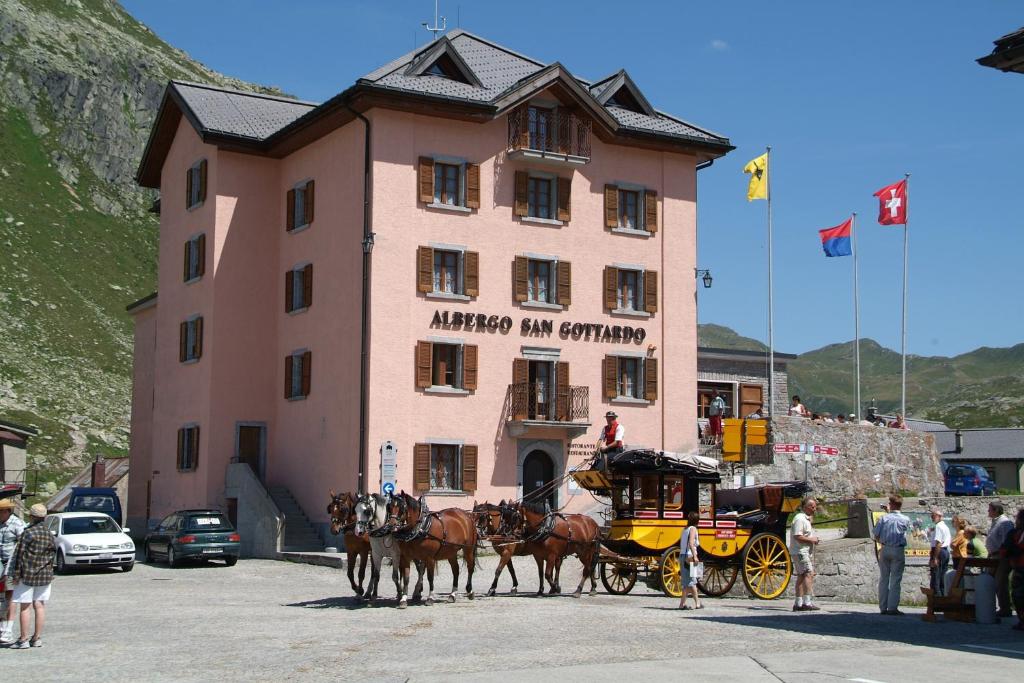 a group of horses pulling a carriage in front of a building at Albergo San Gottardo in Airolo