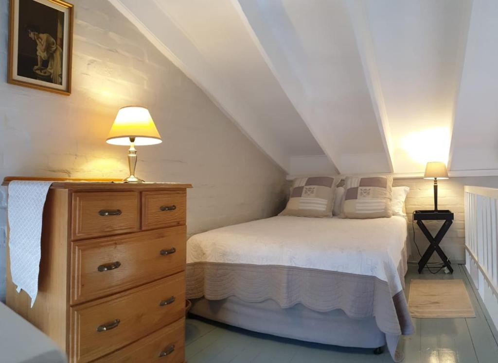 sypialnia z łóżkiem i komodą z lampką w obiekcie Dawn's Place w mieście Strand