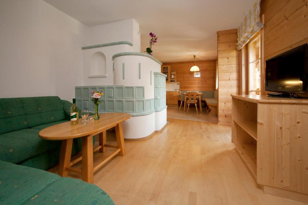 Abelhof في سخلادميخ: غرفة معيشة مع أريكة خضراء وطاولة