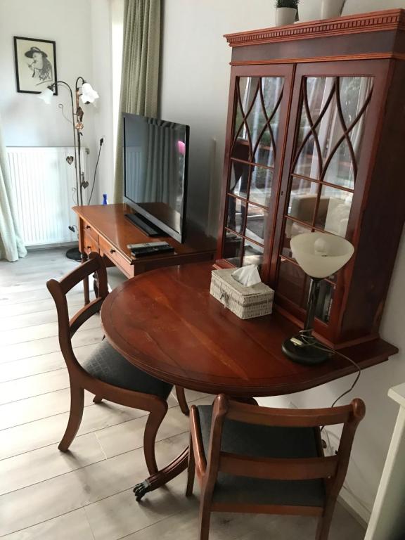 a wooden table with a television and a desk at Villa 't Haasduin in Wijk aan Zee