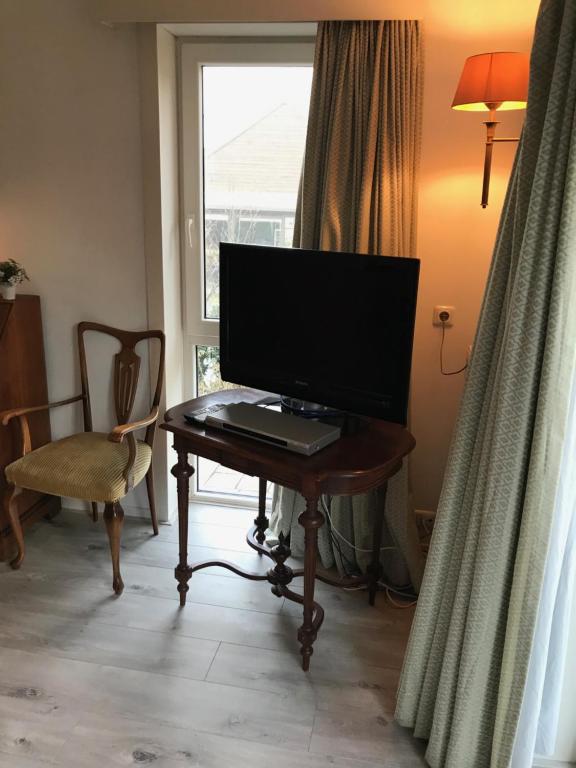 a television sitting on a table in front of a window at Villa 't Haasduin in Wijk aan Zee